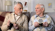 © motortion - Unhappy senior men sitting on sofa holding empty wallets, social insecurity