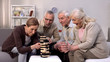 © motortion - Elderly friends building tower from wooden cubes leisure time in nursing home