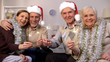 © motortion - Smiling pensioners holding sparklers looking camera, Christmas celebration