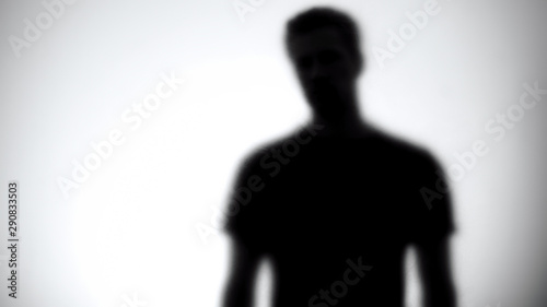 Fotografía Silhouette of male looking at camera through white glass, statistic template