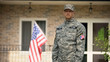 © motortion - Serious military man standing against house, social insurance for war veterans