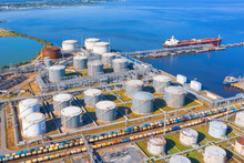 Aerial View Of Large Fuel Storage Tanks At Oil Refinery Industrial Zone In The Cargo Seaport, And Ship Tanker At Unloading.