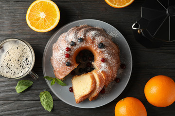 Wall Mural - Cake with powdered sugar, berries and mint on wooden background, top view