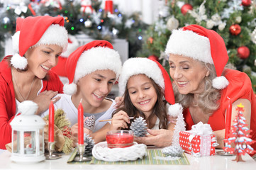 Wall Mural - Portrait of cute smiling family celebrating Christmas together