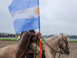 Gaucho riding a horse with the Argentinian flag 