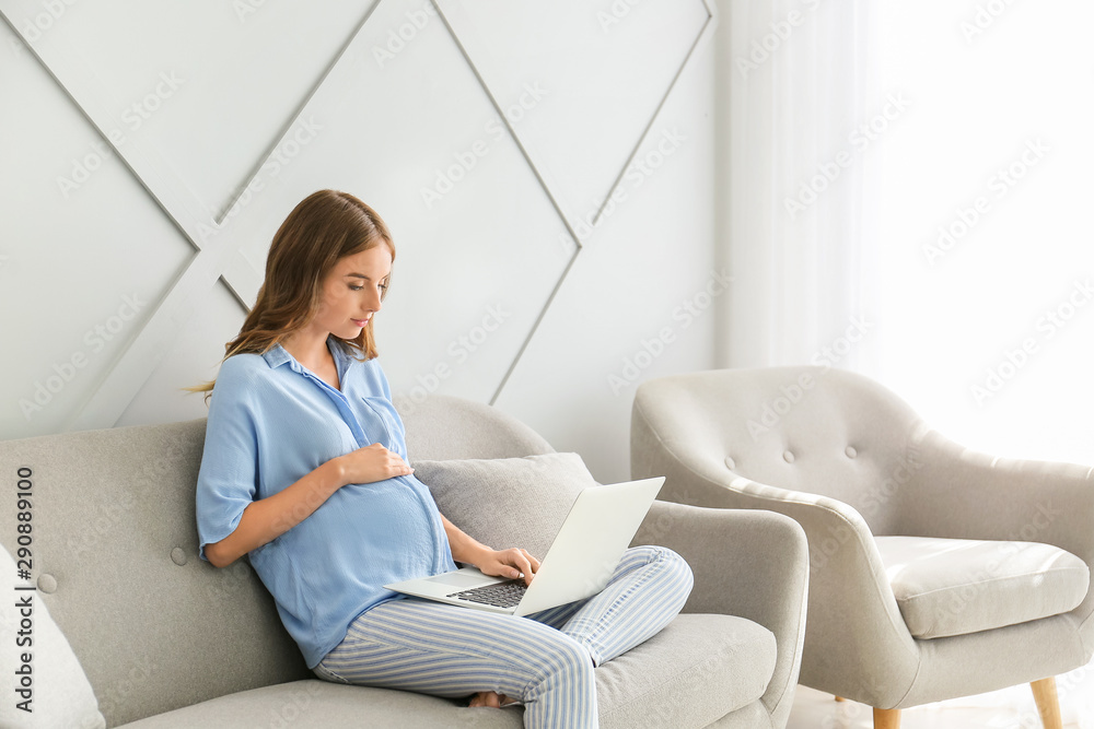 беременная женщина смотрит на ноутбук