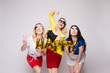 © Вячеслав Косько - Three happy girls keeping balloons, laughing and looking at camera on grey isolated background in studio. Cheerful women celebrating birthday party and posing. Concept of holiday and happiness.