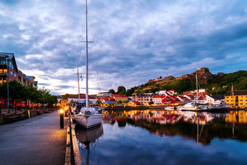 Wall Mural - View of the illuminated houses and yachts with Fredriksted fortress at the background in Halden, Norway