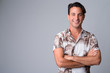 © Ranta Images - Portrait of happy handsome Hispanic tourist man smiling with arms crossed
