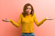 © Asier - Young pretty young woman doubting and shrugging her shoulders in questioning gesture.