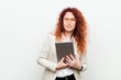 © Asier - Young caucasian business redhead woman holding a tablet happy, smiling and cheerful.
