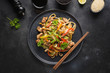 © svetlana_cherruty - Udon stir-fry noodles with pork bowl and vegetables on black stone background. Asian cuisine.