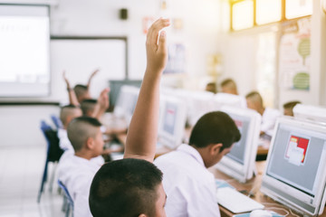 Wall Mural - Student hands up answer a question in class computer at the elementary school. Education concept.
