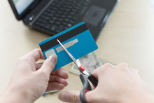 Cutting A Credit Card Using A Scissors. Interest Rates Concept.