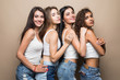 © F8  \ Suport Ukraine - Four attractive women in white shirts and shorts embracing isolated on beige background