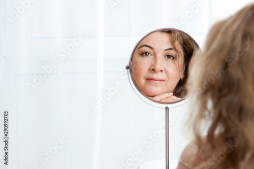 Cuadros en Lienzo Beautiful mature Caucasian woman looking in the mirror