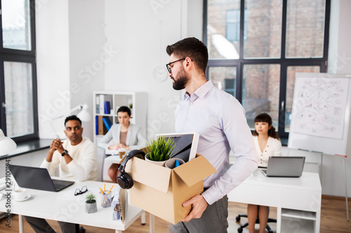 Fotomural business, firing and job loss concept - sad fired male office worker with box of