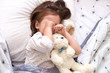 © sementsova321 - Top view of little girl lying in bed with teddy bear, being in bad mood, does not want to srtand up and go to kinder garten, toddler on pillow rubbing her eyes, looks sad. Childhood concept.