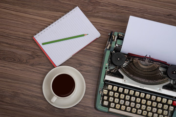 Fototapete - Typewriter on the old wooden desk with coffee cup and note book top view