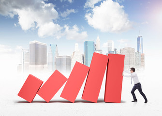 Poster - Businessman holding falling bar chart in city