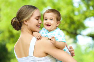 Canvas Print -  Beautiful mother with her cute baby in park on summer day