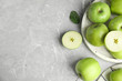 © New Africa - Flat lay composition of fresh ripe green apples on grey stone table, space for text