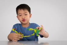 Portrait Of Cute Asian Boy Playing With Colorful Plastic Toy Bri