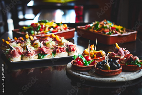 Fotografía Various Tapas-Cups, salads and bread bites on a table at a Tapas Bar