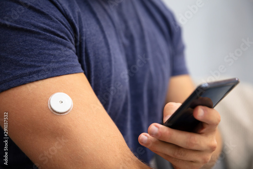 Fotomural Man Checking Glucose Level On Mobile Phone