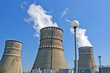 © assistant - Atomic reactor. Operating nuclear power plant. Smoke from the chimney, blue sky. Power Generation
