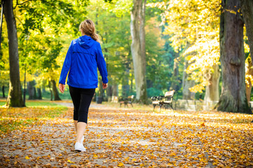 Wall Mural - middle-aged woman walking in city park