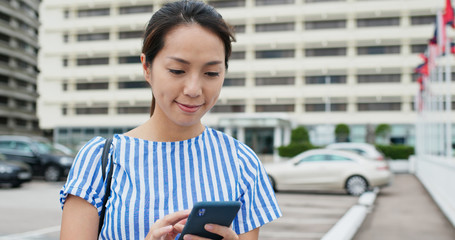 Canvas Print - Woman use of mobile phone with the background car park lot