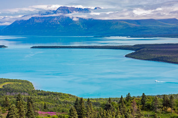 Wall Mural - summer landscape with large lake, mountains and clouds. a small float plane takes off in the distanc