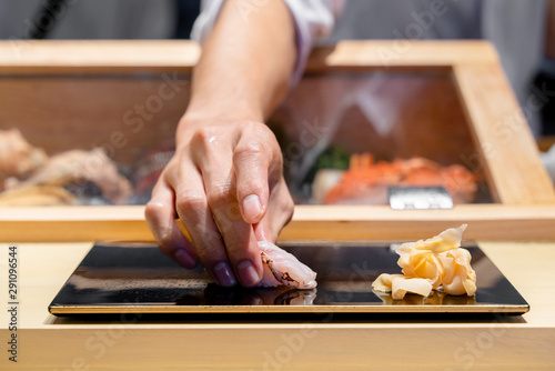 Fotografía Japanese Sushi Chef serve sushi by hand on the black shimmer plate