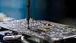 PC technician screws chipset of graphics card to ventilator installing it.