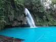 Waterfall with bamboo raft on the turquoise water pool at Kawasan Falls in Cebu Island, Philippines