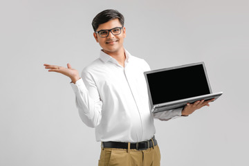 handsome Indian / Asian male student using laptop, isolated on white background