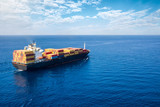 Fototapeta Uliczki - Luftaufnahme eines Containerschiffes in langsamer Fahrt auf offenem Meer