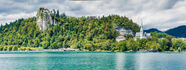 Splendid summer panorama of Lake Bled (Blejsko jezero) is a glacial lake in the Julian Alps in northwestern Slovenia. Sunny morning scene of Bled town and is overlooked by Bled Castle.