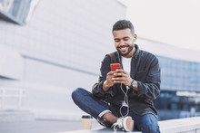 Young Handsome Men Using Smartphone In A City. Smiling Student Man Texting On His Mobile Phone. Coffee Break. Modern Lifestyle, Connection, Business Concept