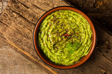 Wall Mural - Homemade guacamole sauce in a rustic bowl