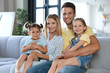 © New Africa - Happy family with little children on sofa in living room