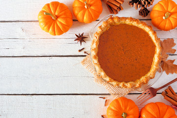 Poster - Homemade autumn pumpkin pie corner border. Top view table scene over a white wood background with copy space.