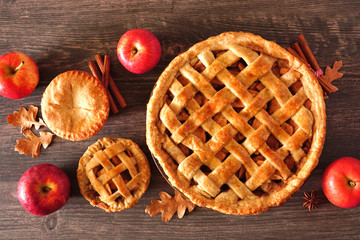 Poster - Homemade autumn apple pies, above view table scene with a dark wood background