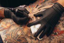 Close Up Tattoo Machine. Tattooing. Man Creating Picture On His Back By A Professional Tattoo Artist.