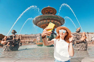 Wall Mural - Happy asian woman taking selfie at the Neptune fountain in Concorde Square. Tour in Paris