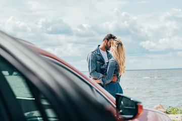 Wall Mural - selective focus of woman and man in denim jackets kissing outside