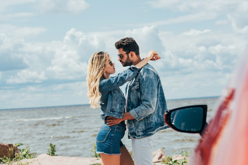 Wall Mural - attractive woman and handsome man in denim jackets hugging outside