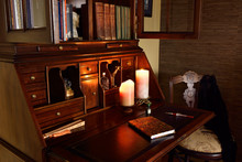 Classic Secretary Writing Desk In Dark Room With Candles And Chair