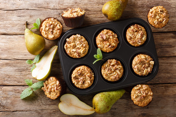 Wall Mural - Only from the oven pear muffins with walnuts, cinnamon and nutmeg in a baking dish close-up. Horizontal top view